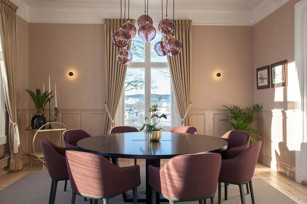 Rundt bord med åtte stoler i hjørnerommet