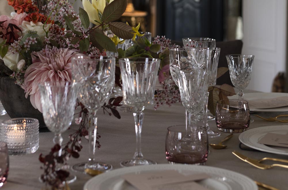 Bord dekket til bryllup med blomster og glass