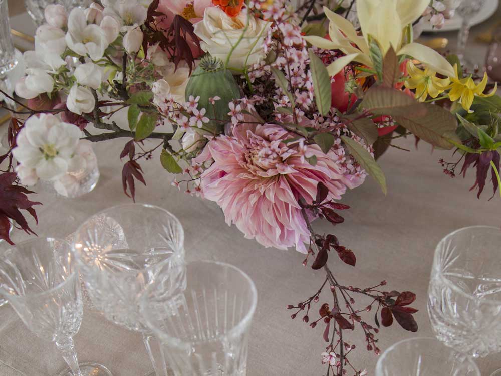 Blomster og glass på dekket bord hos Kjeller Gaard